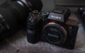 Sony FE 50mm f/1.4 GM G Master lens positioned beside black Sony full-frame mirrorless camera body