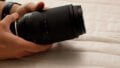 A man holding a Tamron 70-180mm f/2.8 Di III VXD lens