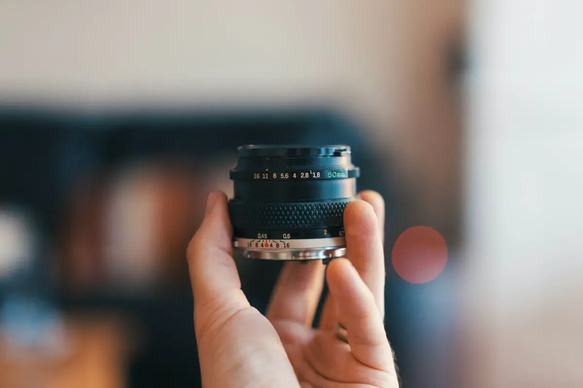 A close-up image of a camera's lens focused on a vividly detailed butterfly wing, with subtle overlays of editing interface sliders representing sharpness, contrast, and resolution adjustments