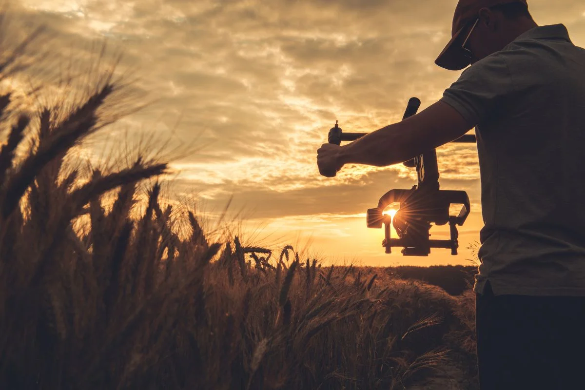 Best Gimbal for Sony A6000 1 A man using a gimbal for his camera in a grass field
