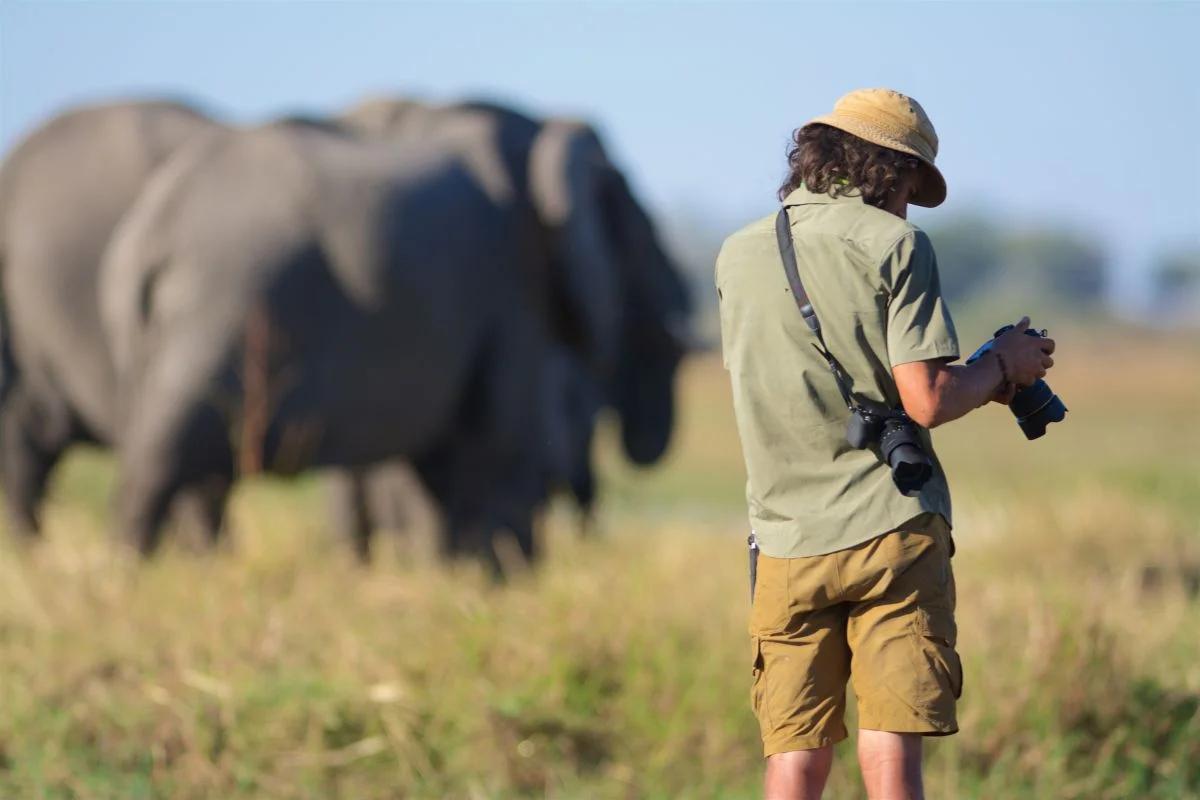 A man in the jungle using the best wildlife lens for Sony A6000