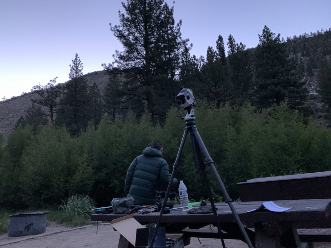 Carbon fiber tripod set up outdoors at dusk with a camera mount